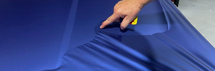Installer lifting Briteline ColorCAST Matte Azul Steel Metallic color change vinyl film during application