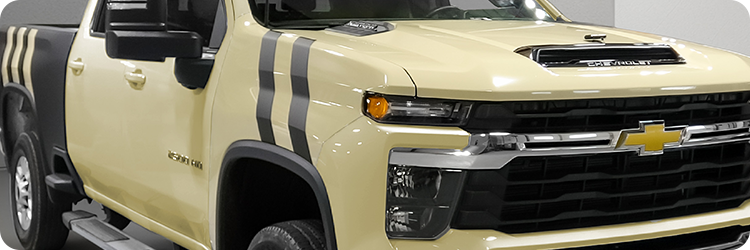 Chevrolet Silverado truck wrapped using Briteline ColorCAST vinyl in colors Gloss Stonehenge Beige as a base and Matte Black accept racing stripes.